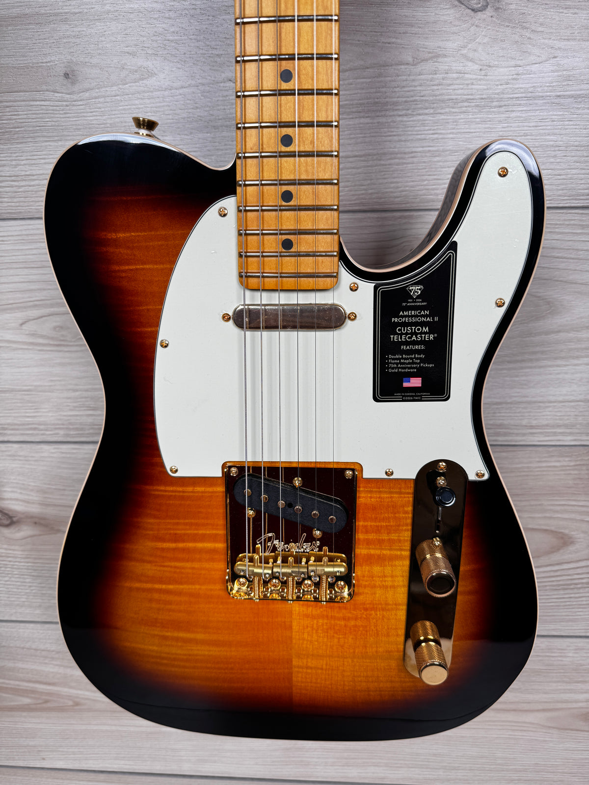 A Fender Telecaster electric guitar with a sunburst finish, white pickguard, and gold hardware, American professional II 75 anniversary